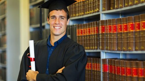 How to get an A in legal studies. Boy graduates in front of law books