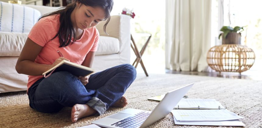 Teen studies on laptop on loungeroom floor