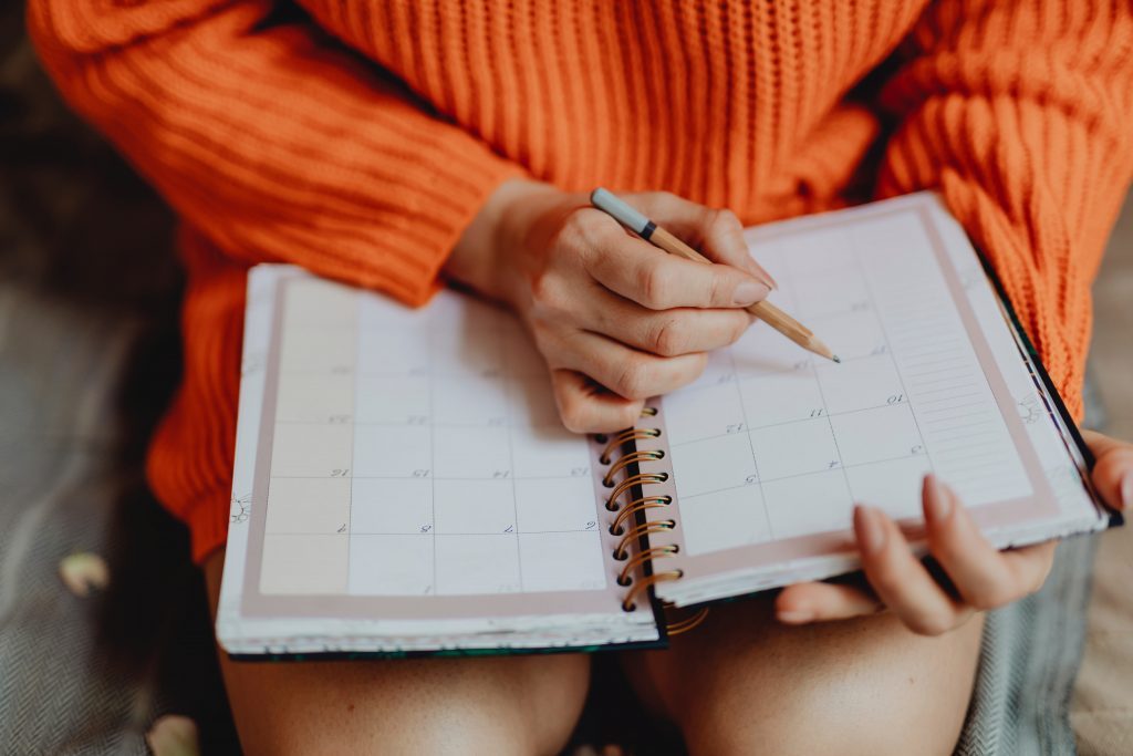 Teen girl organises her study schedule in her diary